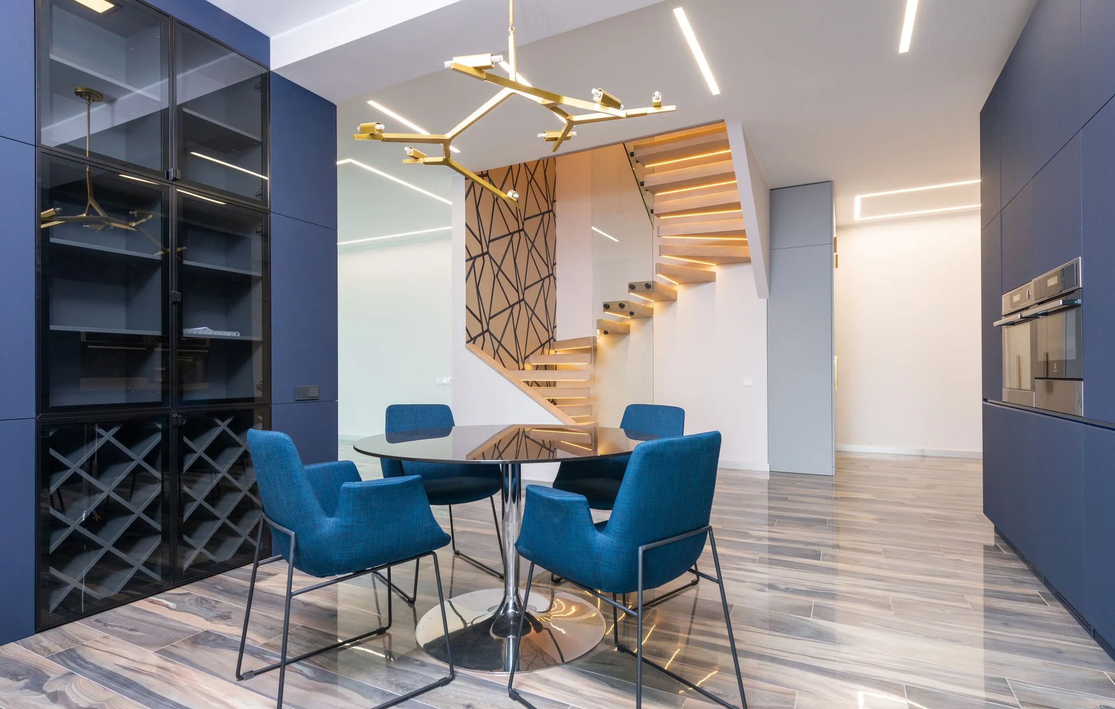 Sculptural brass chandelier above a dining table in a modern interior